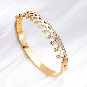 Golden crown titanium steel bracelet with sparkling zircons on white silk background