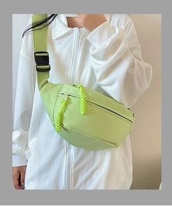 Détail d'un sac de poitrine en nylon imperméable vert clair avec tirettes tressées