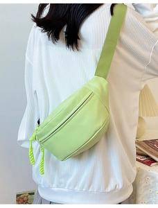 Gros plan d'un sac banane vert citron avec sangle tissée porté par un mannequin