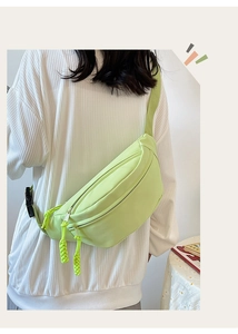Détail du sac de poitrine vert clair avec tissu lisse et tirettes de fermeture en corde