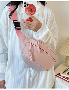 Détail d'un sac banane rose en demi-lune avec tirette tressée et sangle réglable