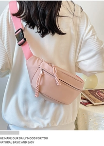 Détail du sac de poitrine en nylon rose clair avec sangle réglable et fermetures éclair tissées