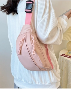 Vue latérale d'un sac de poitrine en nylon rose clair avec sangle et boucle de fermeture