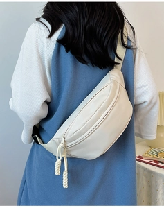Détail d'un sac banane demi-lune crème avec fermetures à glissière en corde tressée