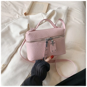 Detailed macro view of pink crocodile-embossed vanity case bag with silver zipper