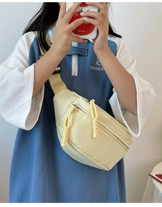 Détail du sac de poitrine jaune pâle avec tirettes tressées et large bandoulière