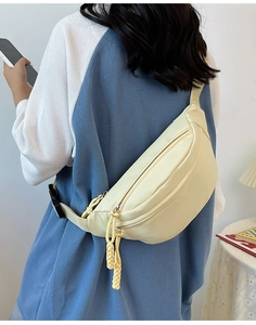 Détail du sac de poitrine en nylon crème avec double fermeture éclair et sangle