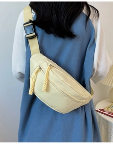 Détail du sac de poitrine crème avec sangle réglable et tirettes de fermeture tissées