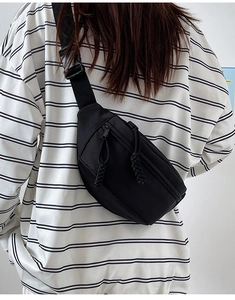Détail du sac de poitrine en nylon noir avec doubles fermetures et sangle réglable
