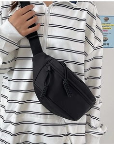 Détail du sac de poitrine en nylon noir avec doubles zips et tirettes en corde tressée
