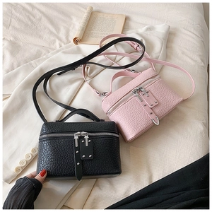 Detail of vintage croc-embossed crossbody bags with dual zippers and metal rivets