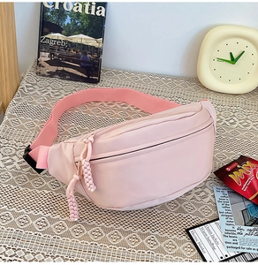 Détail du sac de poitrine en nylon rose clair avec tirettes de fermeture tressées décoratives
