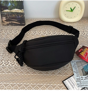 Détail du sac de poitrine minimaliste en nylon noir sur une nappe en dentelle
