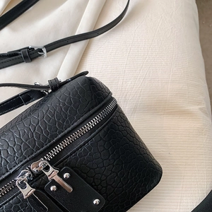 Classic black embossed leather camera bag with dual silver zippers and adjustable strap