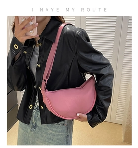 Pink nylon crescent shoulder bag shown in a stylish mirror selfie with a wide strap