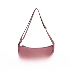 Detail of dusty rose nylon crescent bag showing size comparison with a smartphone