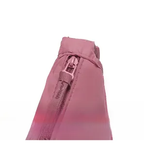Close-up of smooth pink zipper hardware and nylon fabric texture on a shoulder bag