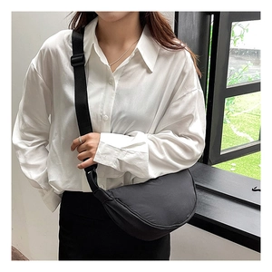 Model wearing a black nylon crescent bag showing the adjustable shoulder strap length
