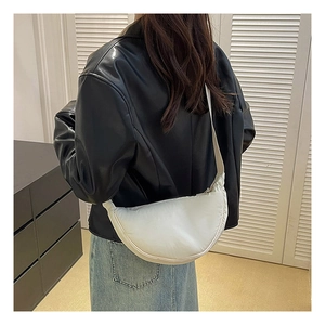 Rear view of a white nylon crescent shoulder bag shown on model in a casual outfit