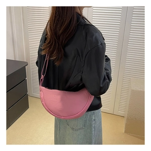 Pink nylon hobo bag shown as an underarm shoulder bag on model for size perspective