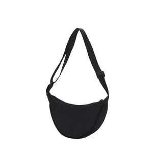 Detail view of black nylon crescent bag featuring adjustable wide strap and zip closure