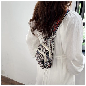 Rear view of a model wearing a mini ethnic style chest bag with colorful woven straps