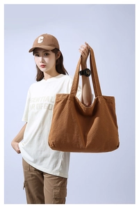 Brown large capacity canvas tote bag worn by model for casual daily outfit style