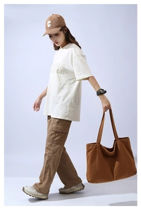 Fashionable model style featuring a minimalist white t-shirt and brown canvas tote bag