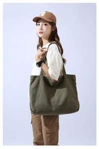 Olive green canvas tote bag detail showing large capacity and minimalist design