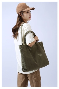 Detail view of large olive green canvas tote bag with long shoulder straps for daily use