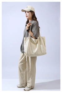 Detailed view of spacious beige canvas tote bag with wide straps for daily shoulder use