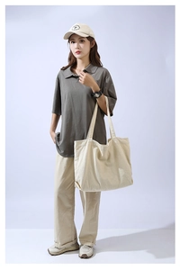 Minimalist beige canvas tote bag styled with casual outfit on a light blue background