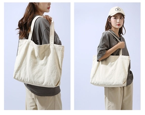 Close-up of thick textured canvas tote bag fabric in cream white showing dual straps