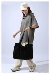 Minimalist black large canvas tote bag styled with casual outfit in studio setting