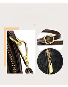Detail of golden hardware and adjustable strap hooks on a black textured leather bucket bag