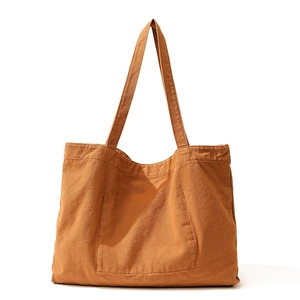 Minimalist caramel brown canvas tote bag with front pocket and wide shoulder straps