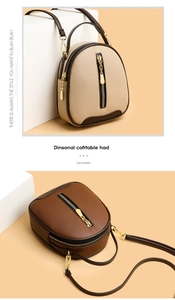Detail view of mini semi-circular bucket bag with lychee texture and gold zippers