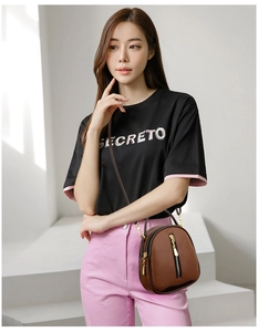 Detail of brown litchi pattern leather bucket bag with vertical gold zipper and strap