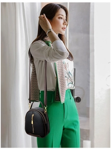 Detail showing the textured black lychee leather and stylish zipper of the bucket bag