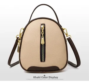 Detail view of khaki pebbled leather bucket bag with brown trim and golden zipper