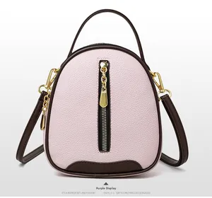 Close-up of pebble grain purple leather bucket bag with brown handles and gold hardware
