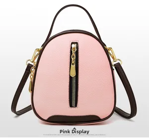 Detailed front view of pink bucket bag with brown contrast trim and golden zipper