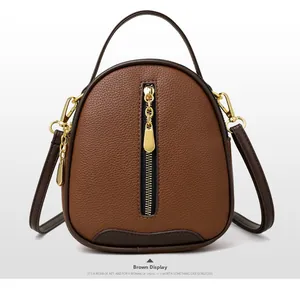 Detail of brown pebbled leather bucket bag with gold hardware and vertical zipper