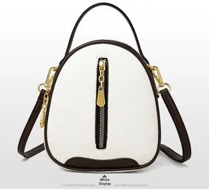 Close-up detail of white and brown lychee grain leather mini crossbody bucket bag