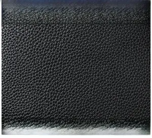 Close-up of premium black litchi grain leather texture with soft and detailed finish