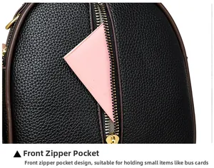 Close-up of litchi textured black bucket bag featuring a front zipper pocket for cards