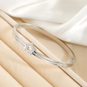 Bracelet étoile argenté poli avec cristaux micro-pavés sur support en velours beige