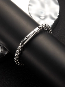Dettaglio di un bracciale a catena box argento da uomo con chiusura cilindrica su supporto