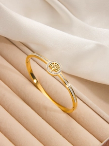 Détail d'un bracelet jonc plaqué or 18 carats avec motif arbre de vie et zircons