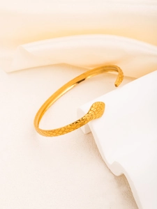 Detailed view of the gold-plated snake scale texture and C-shaped opening design